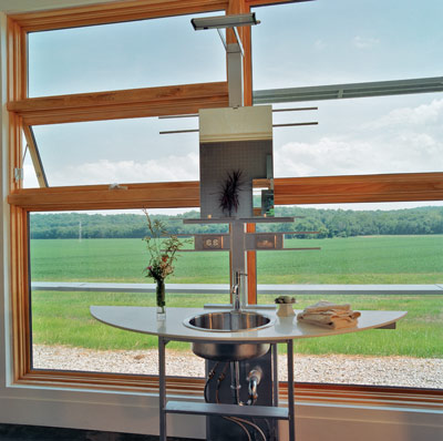 Freestanding handmade steel lavatories, designed and built by the architects, were placed in the hallways so the homeowner and guests can look out onto the southern view. “It’s such a fantastic landscape—you fall right into it,” Rockhill says. The mirror reflects the private toilet and tub room finished in two-inch mosaic tile.